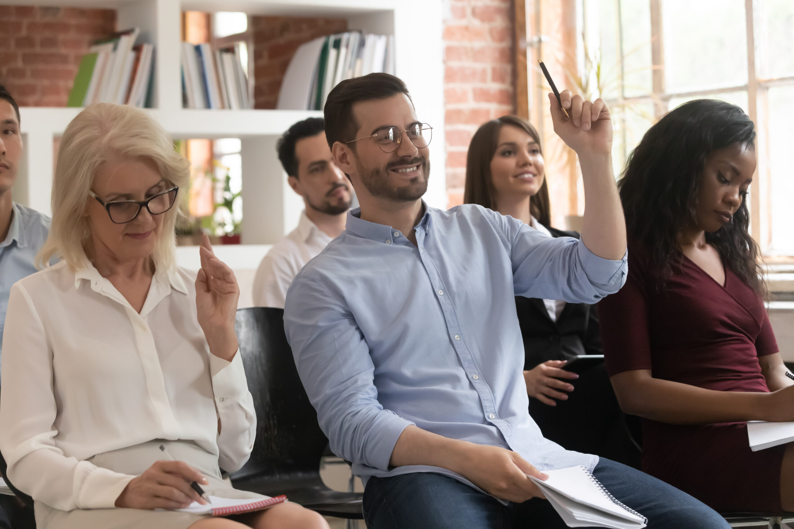 Training audience participants raise hands up ask question at conference